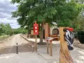 Escultura de pájaro carpintero en la ruta de Ferreruela de Huerva. Señalización informativa y camino de tierra.