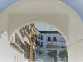 Un arco blanco enmarca edificios blancos y ocres con balcones de hierro forjado. Descubre qué ver en Marchena, un rincón andaluz lleno de encanto.