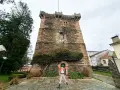 Persona salta de alegría frente a la Torre de los Andrade, un lugar imprescindible que ver en Pontedeume.