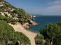La cala de Sant Francesc, con sus aguas turquesas y arena dorada, se asoma entre pinos y casas blancas en la ladera.