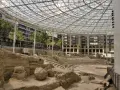 Antiguas ruinas romanas en Zaragoza, protegidas bajo una moderna estructura de cristal y metal.