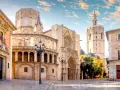 Plaza de la Virgen, un lugar imprescindible que ver en Valencia. La Catedral y el Micalet se alzan majestuosos bajo un cielo azul.