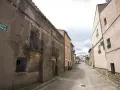 Calle Italia en Villar del Salz, un pueblo con casas antiguas y un cielo nublado.
