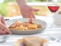 Un plato de paella de marisco servido con vino tinto, ideal para saber donde comer en Menorca.