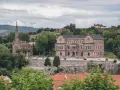 Edificio neogótico y palacio en Comillas, rodeados de vegetación y colinas. Un lugar para ver y disfrutar.