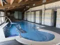 Piscina interior con cascadas y escaleras de piedra, ideal para relajarse en las **Vilas del Turbon**.