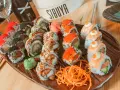 Variedad de sushi en plato marrón, ideal para saber donde comer en Vitoria. Incluye rollos con salmón, huevas de pez volador, aguacate y tempura.