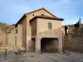 Ruinas del castillo de Mesones de Isuela, con una estructura de ladrillo y piedra bajo un cielo azul.