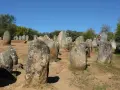 Un hombre y una niña juegan entre las piedras de un cromlech, un antiguo monumento megalítico.