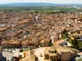 Vista aérea de un pueblo español con tejados de teja, donde se alza la torre de una iglesia. La **ejea de los caballeros** se extiende hasta el horizonte.