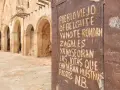 Ruinas de Belchite, Zaragoza. Una puerta oxidada muestra un mensaje sobre el pueblo viejo y las jotas que ya no se oyen.