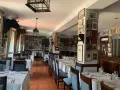 Mesas puestas para comer en ronda, decorado con cabezas de toro y carteles taurinos.