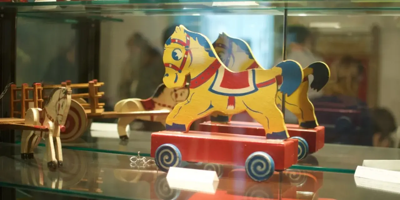 Caballitos de madera amarillos y rojos, parte de una exhibición en el museu de la joguina sant feliu de guixols.