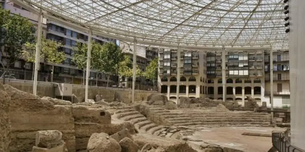 Antiguas ruinas romanas en Zaragoza, protegidas bajo una moderna estructura de cristal y metal.