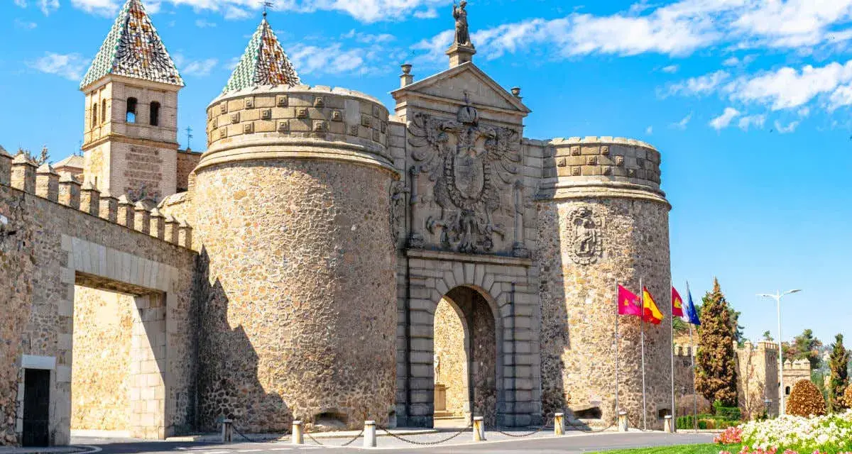 Puerta de Bisagra en Toledo, un lugar imprescindible que ver en Toledo. Impresionante entrada amurallada con escudos y torres.