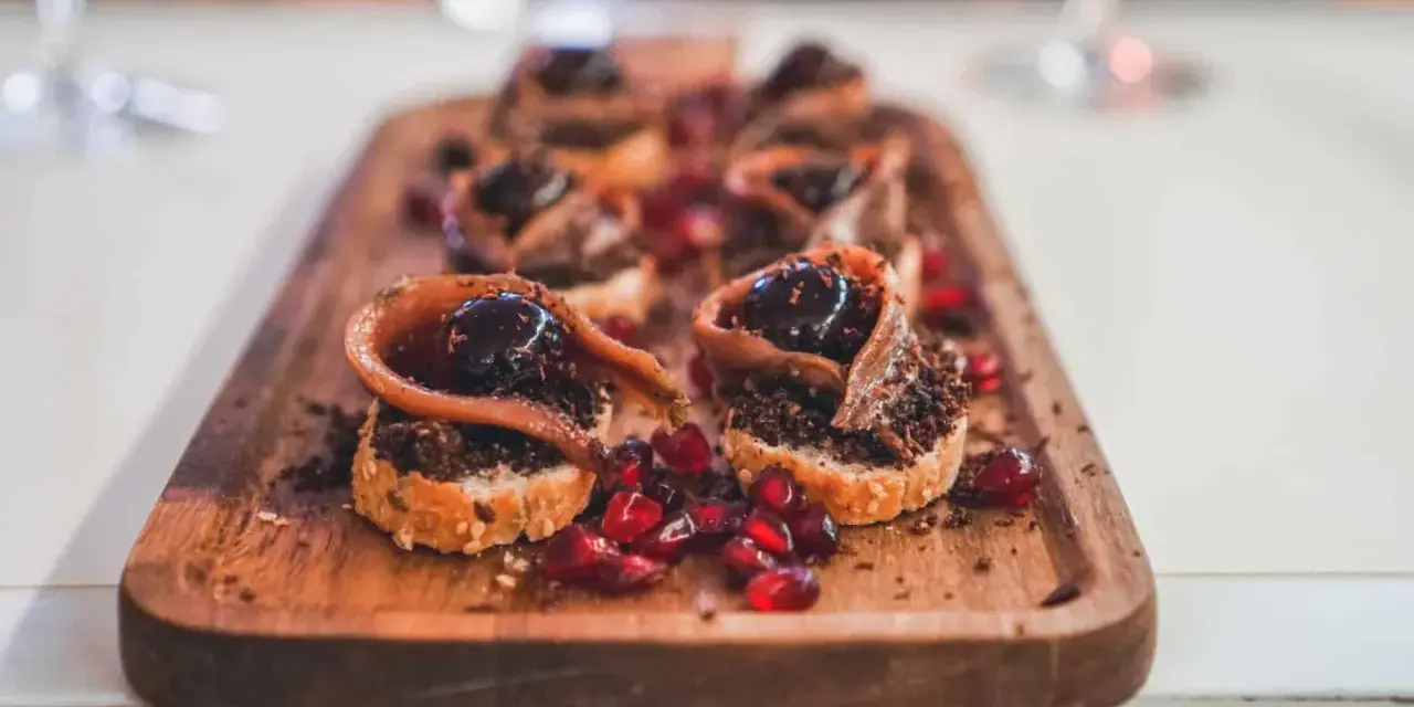Deliciosos pinchos con anchoa, aceituna y granada, perfectos para comer en Burgos.
