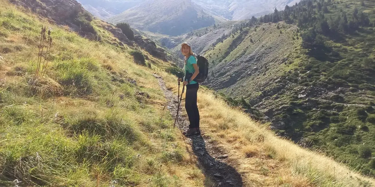 Senderista en el **valle de Chistau**, disfrutando de la vista de las montañas y la vegetación.