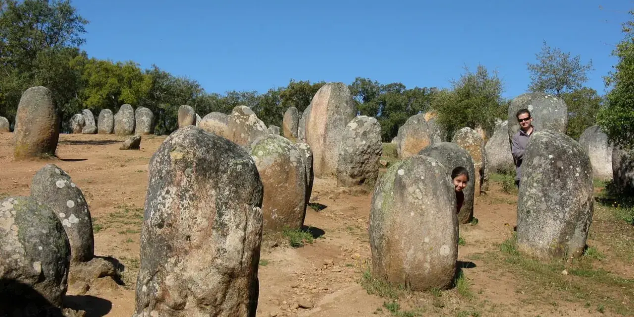Un hombre y una niña juegan entre las piedras de un cromlech, un antiguo monumento megalítico.