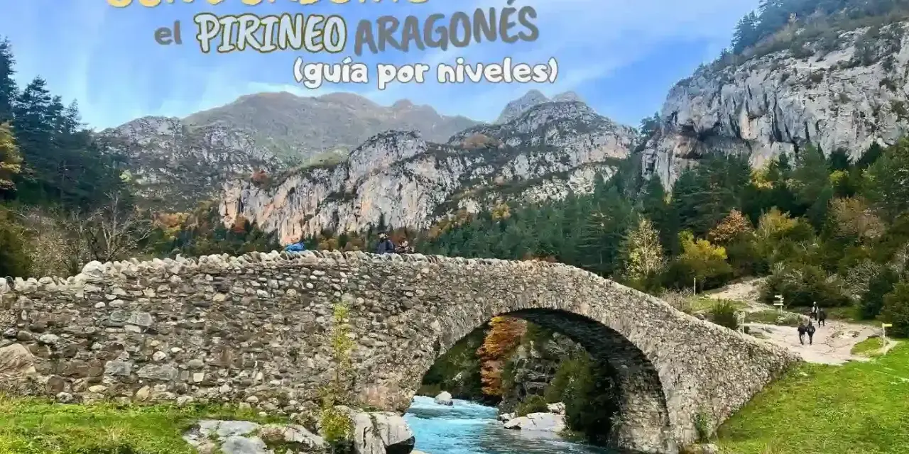Puente de piedra sobre río turquesa en la montaña de Pirineos. Senderismo en el Pirineo Aragonés.