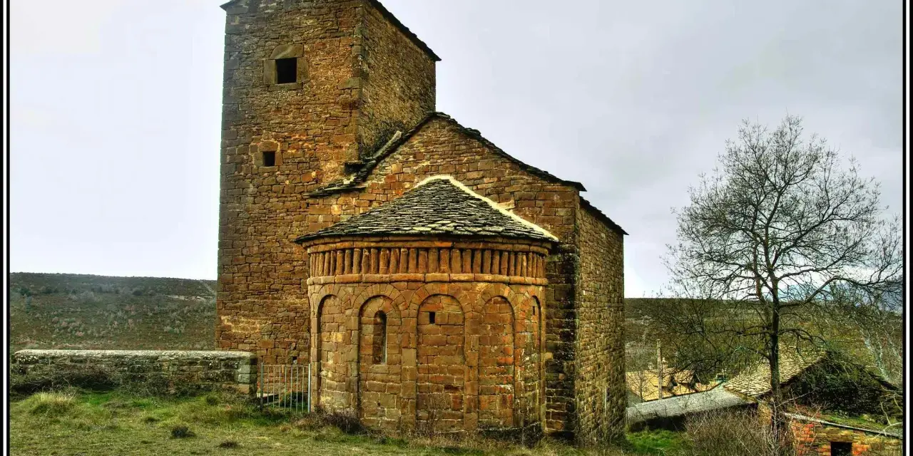Antigua iglesia románica de piedra, una de las iglesias del Serrablo, con su torre cuadrada y ábside semicircular.