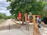 Escultura de pájaro carpintero en la ruta de Ferreruela de Huerva. Señalización informativa y camino de tierra.