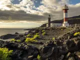 Faros gemelos en la costa rocosa, un destino que ver en La Palma. El mar y el cielo nublado completan la escena.