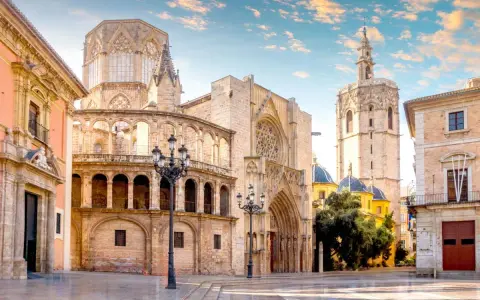 Plaza de la Virgen, un lugar imprescindible que ver en Valencia. La Catedral y el Micalet se alzan majestuosos bajo un cielo azul.