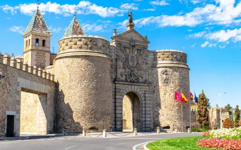 Puerta de Bisagra en Toledo, un lugar imprescindible que ver en Toledo. Impresionante entrada amurallada con escudos y torres.