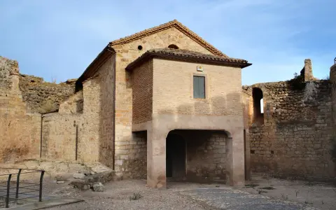 Ruinas del castillo de Mesones de Isuela, con una estructura de ladrillo y piedra bajo un cielo azul.