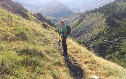 Senderista en el **valle de Chistau**, disfrutando de la vista de las montañas y la vegetación.