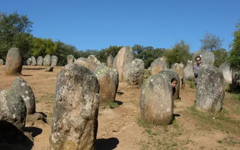 Un hombre y una niña juegan entre las piedras de un cromlech, un antiguo monumento megalítico.