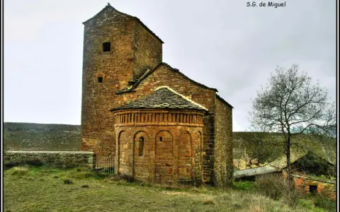 Antigua iglesia románica de piedra, una de las iglesias del Serrablo, con su torre cuadrada y ábside semicircular.