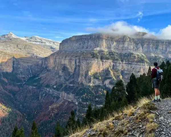 Senderista admira el imponente paisaje de los Pirineos. Las **rutas Pirineos** ofrecen vistas espectaculares de cañones y cascadas.