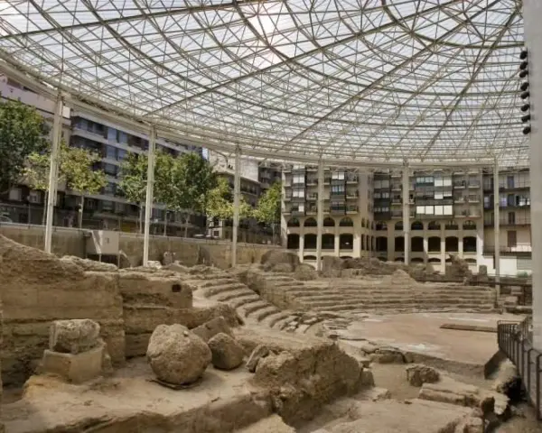 Antiguas ruinas romanas en Zaragoza, protegidas bajo una moderna estructura de cristal y metal.