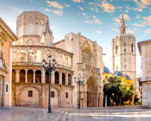 Plaza de la Virgen, un lugar imprescindible que ver en Valencia. La Catedral y el Micalet se alzan majestuosos bajo un cielo azul.