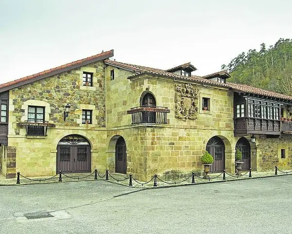 Edificio histórico de piedra con balcones de madera, ideal para saber donde comer en Lierganes.