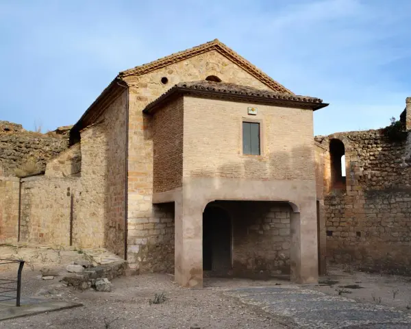 Ruinas del castillo de Mesones de Isuela, con una estructura de ladrillo y piedra bajo un cielo azul.