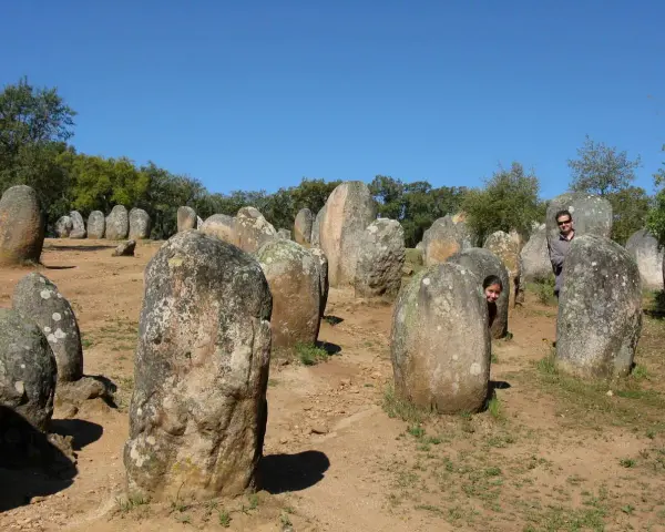 Un hombre y una niña juegan entre las piedras de un cromlech, un antiguo monumento megalítico.