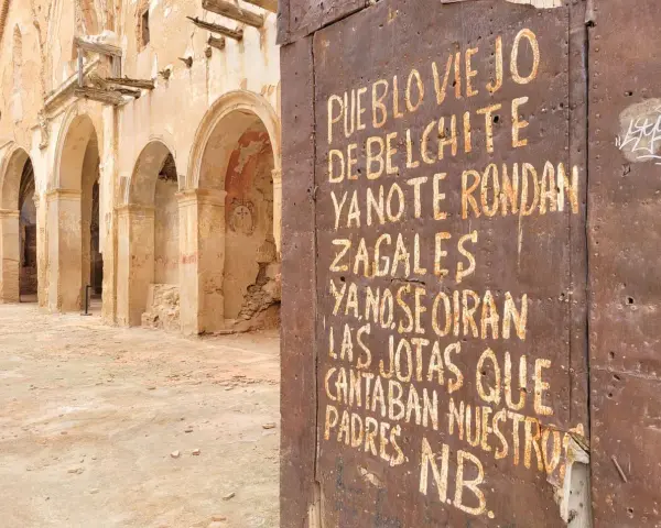 Ruinas de Belchite, Zaragoza. Una puerta oxidada muestra un mensaje sobre el pueblo viejo y las jotas que ya no se oyen.