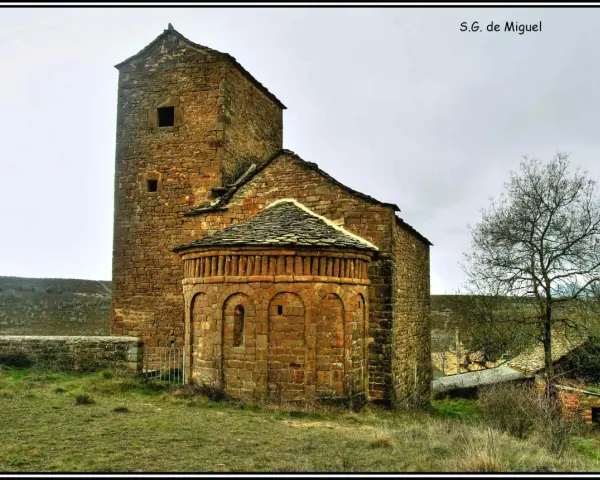 Antigua iglesia románica de piedra, una de las iglesias del Serrablo, con su torre cuadrada y ábside semicircular.