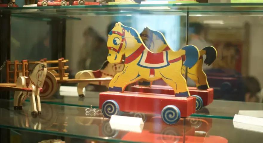 Caballitos de madera amarillos y rojos, parte de una exhibición en el museu de la joguina sant feliu de guixols.