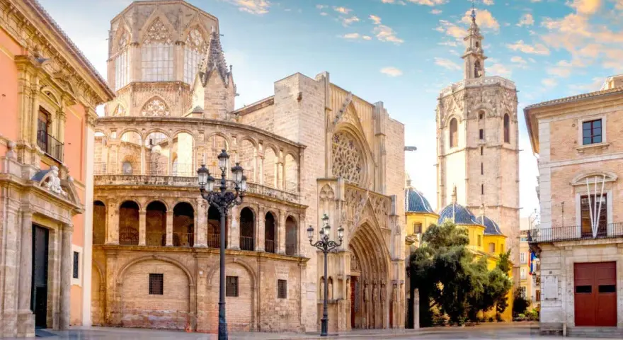 Plaza de la Virgen, un lugar imprescindible que ver en Valencia. La Catedral y el Micalet se alzan majestuosos bajo un cielo azul.