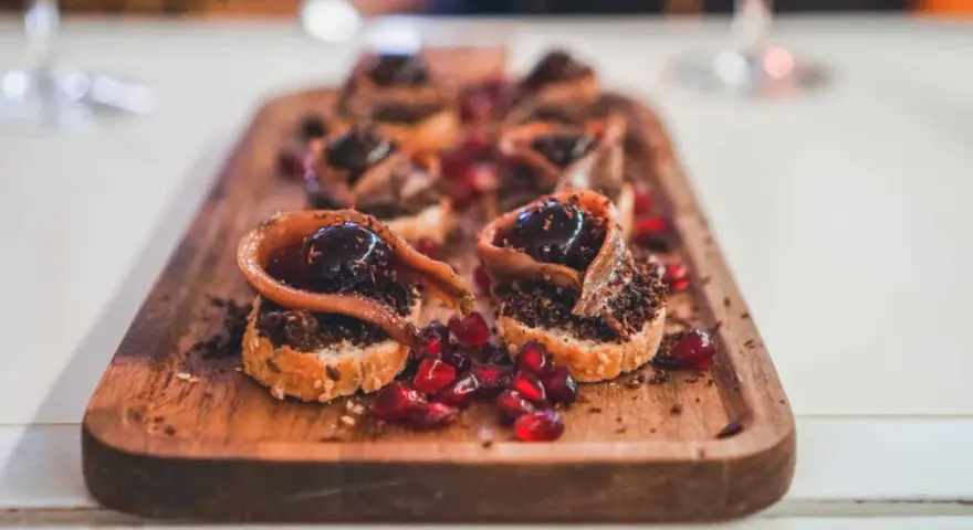 Deliciosos pinchos con anchoa, aceituna y granada, perfectos para comer en Burgos.