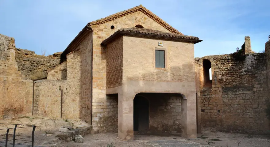 Ruinas del castillo de Mesones de Isuela, con una estructura de ladrillo y piedra bajo un cielo azul.