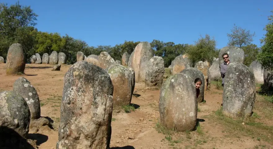 Un hombre y una niña juegan entre las piedras de un cromlech, un antiguo monumento megalítico.
