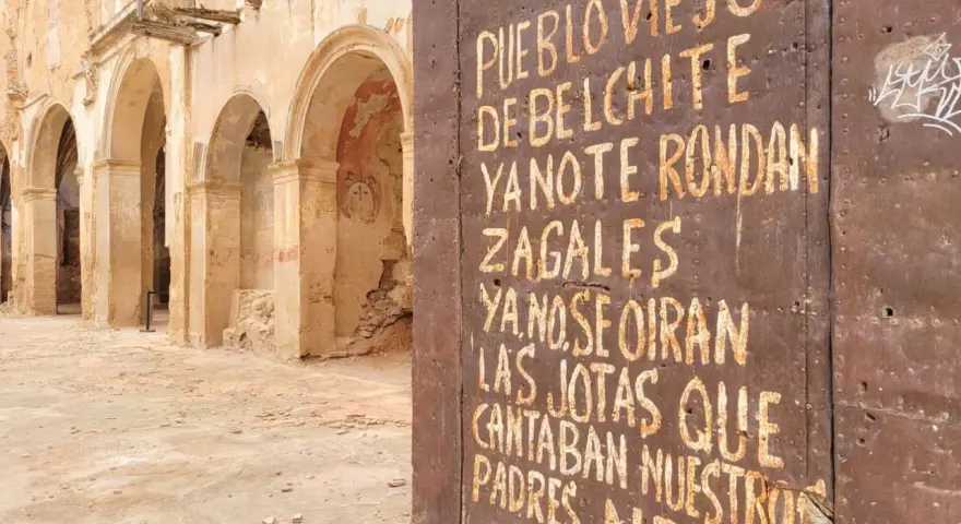 Ruinas de Belchite, Zaragoza. Una puerta oxidada muestra un mensaje sobre el pueblo viejo y las jotas que ya no se oyen.