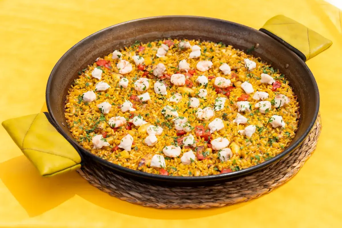 Paella de marisco y pescado, perfecta para saber donde comer en Almer&iacute;a. Arroz amarillo con gambas, trozos de pescado blanco y pimientos rojos.