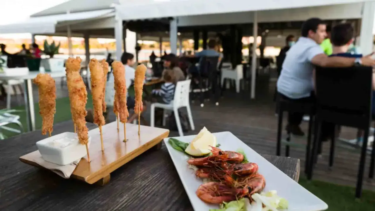 Deliciosos langostinos y calamares rebozados, perfectos para saber donde comer en Zaragoza. Ambiente agradable con gente cenando al fondo.