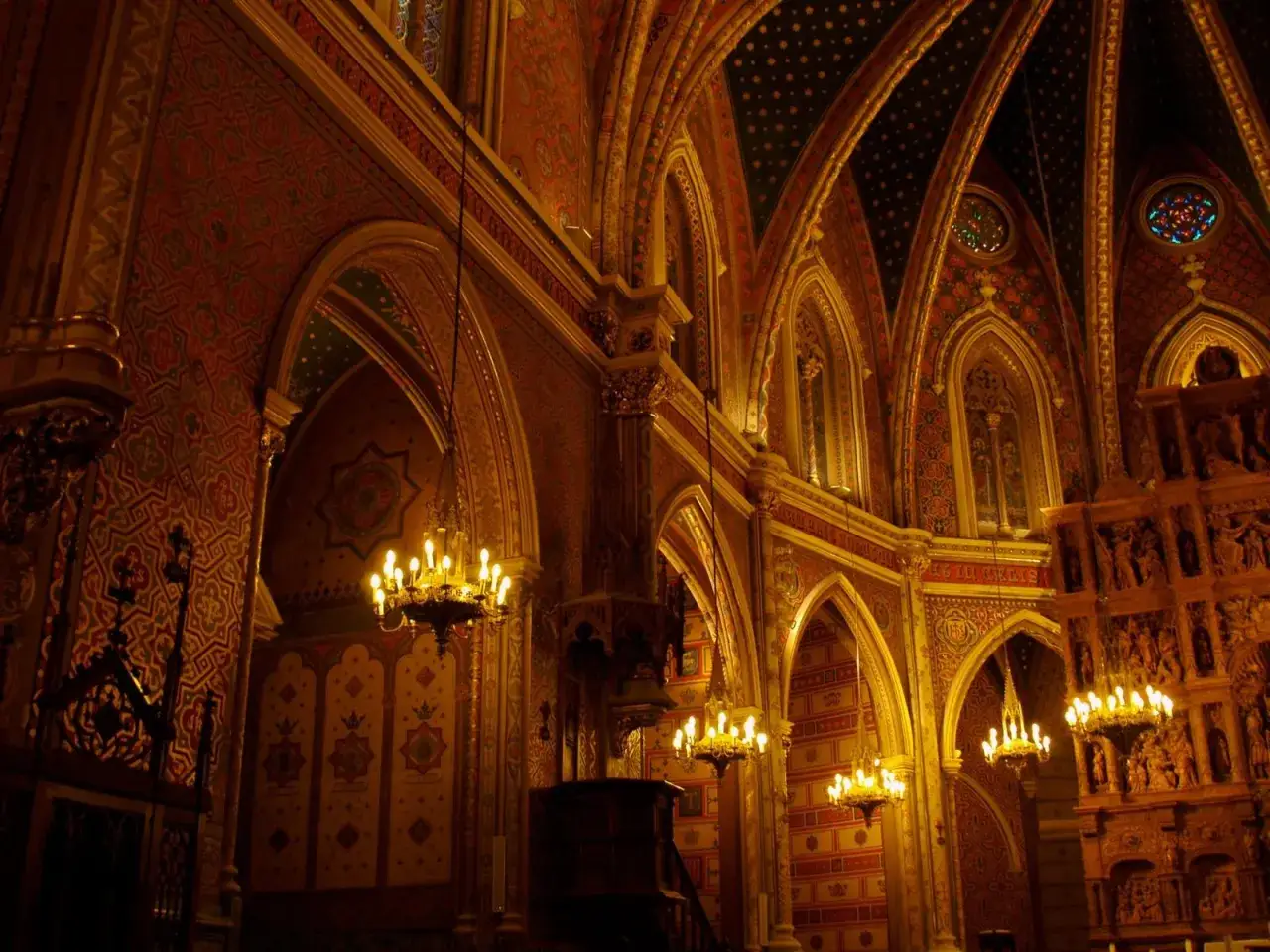 Interior de la iglesia de San Pedro de Teruel, con arcos góticos, lámparas doradas y ornamentación detallada en paredes y techos.