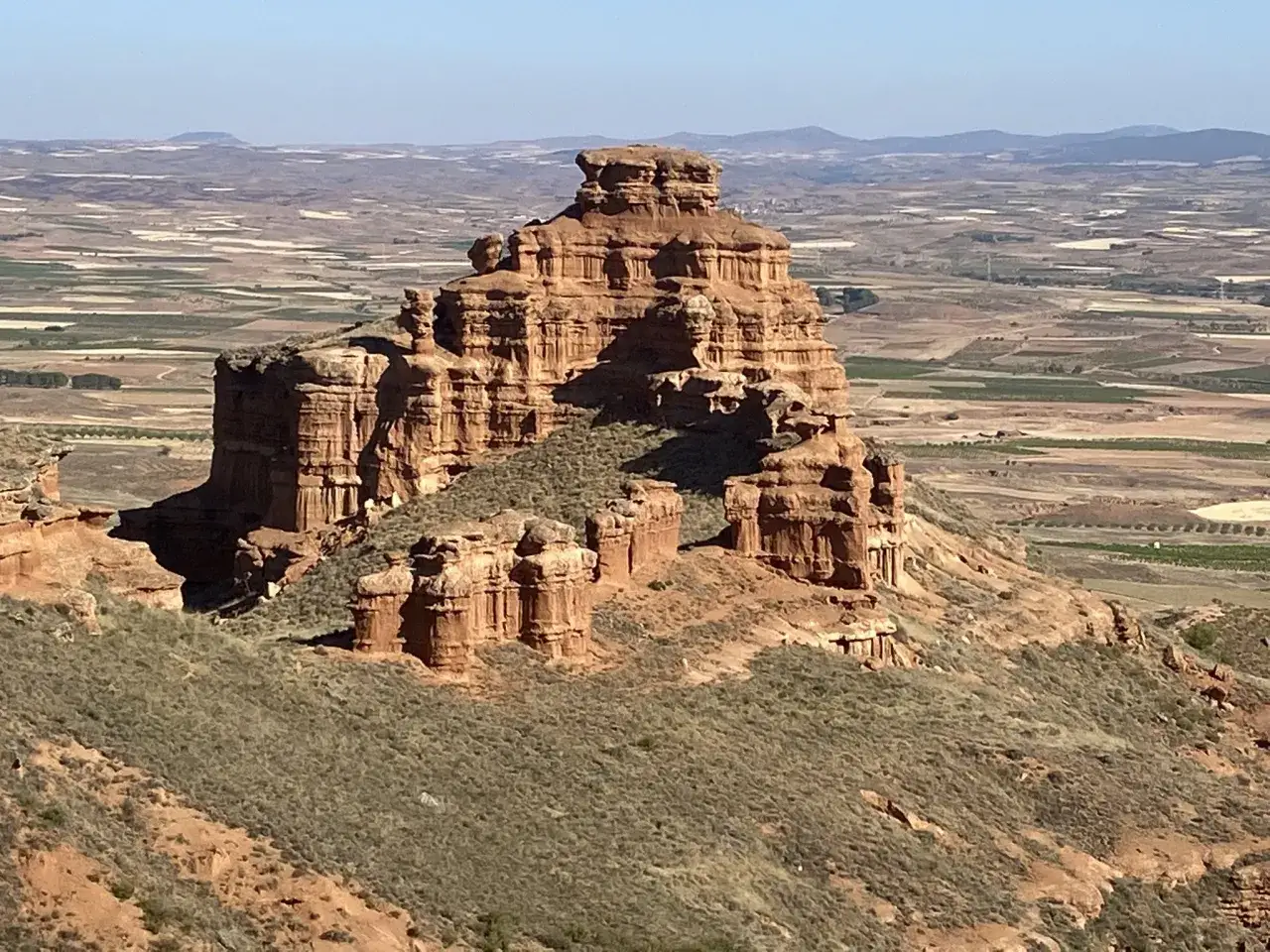 Impresionante formación rocosa en Villarroya de la Sierra, con el valle y campos cultivados al fondo.